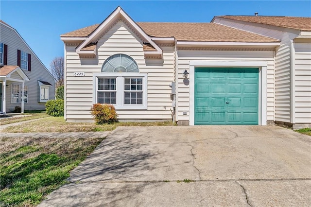 view of front of house with an attached garage, a shingled roof, and driveway