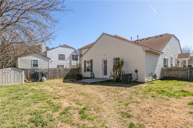 back of house featuring an outdoor structure, a yard, a patio area, and a fenced backyard