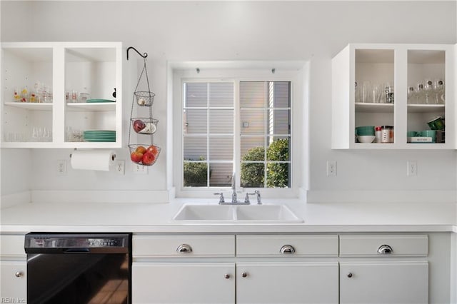 kitchen featuring glass insert cabinets, light countertops, black dishwasher, white cabinets, and a sink