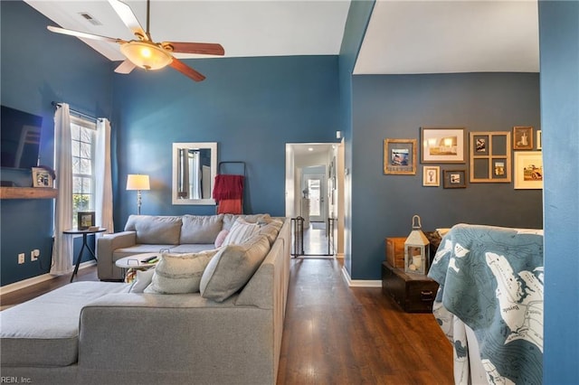 living area with a ceiling fan, visible vents, wood finished floors, and baseboards