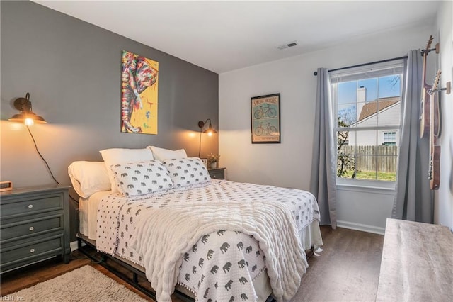 bedroom with dark wood finished floors, baseboards, and visible vents