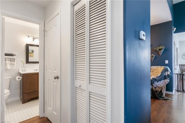 hall featuring baseboards and wood finished floors