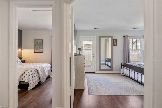 bedroom with visible vents, baseboards, and wood finished floors