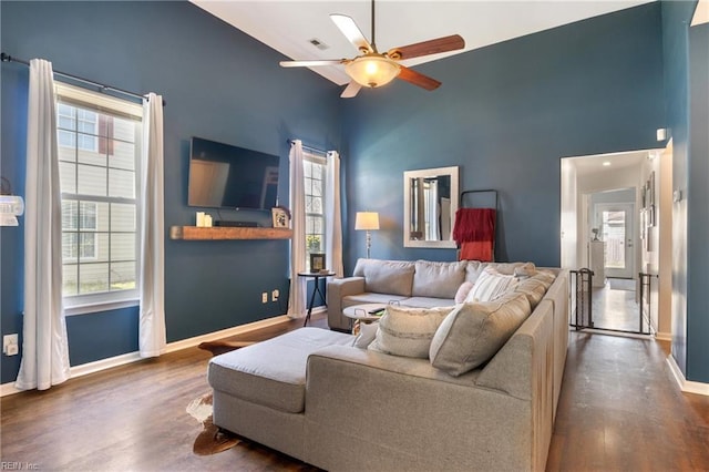 living room featuring high vaulted ceiling, baseboards, a ceiling fan, and wood finished floors