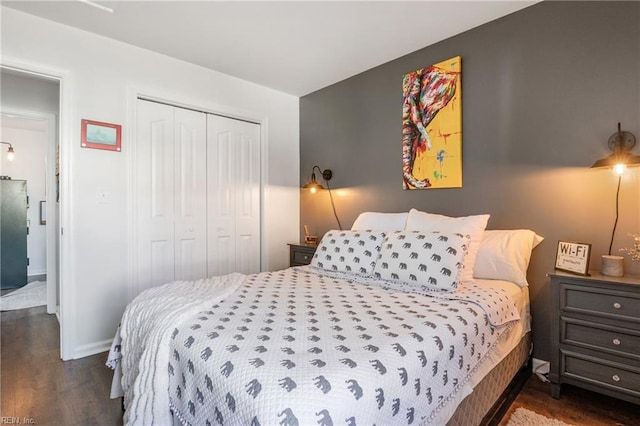 bedroom with a closet, baseboards, and wood finished floors