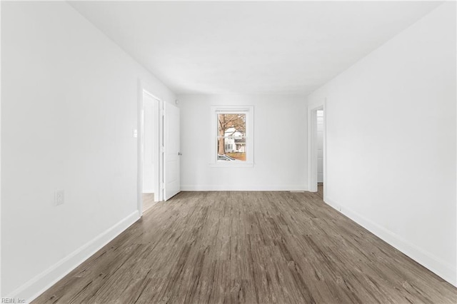 unfurnished room featuring baseboards and wood finished floors