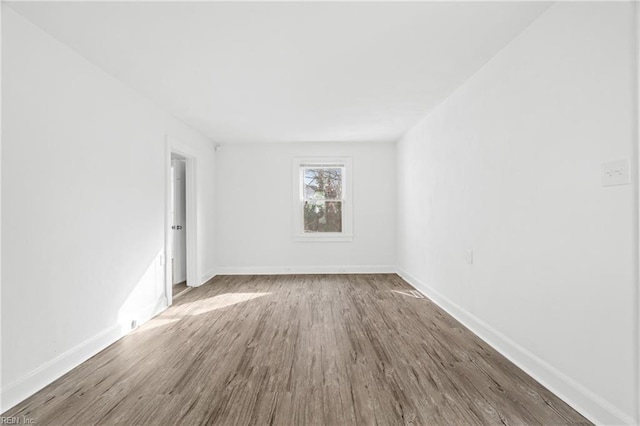 empty room featuring baseboards and wood finished floors