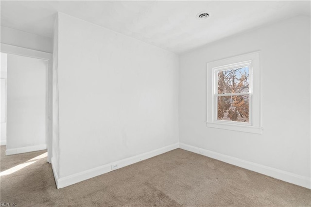 spare room featuring visible vents, baseboards, and carpet