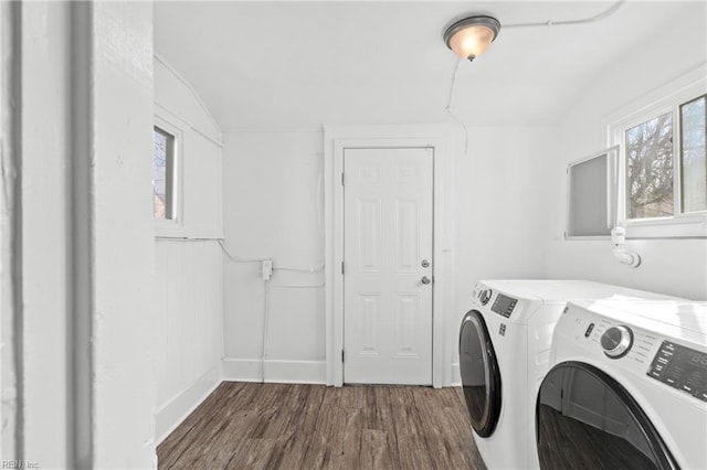 clothes washing area with baseboards, wood finished floors, washing machine and dryer, and laundry area