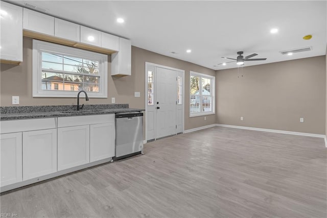 kitchen with a sink, light wood-style floors, dishwasher, and white cabinets