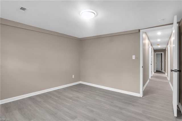 spare room with visible vents, baseboards, and light wood finished floors