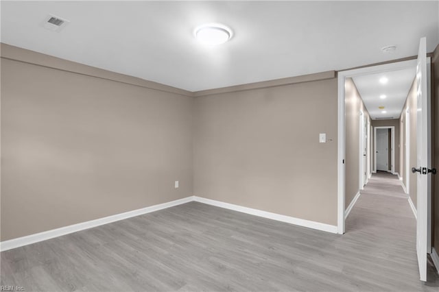 unfurnished room with visible vents, baseboards, and wood finished floors