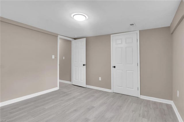 unfurnished bedroom featuring light wood finished floors, visible vents, and baseboards