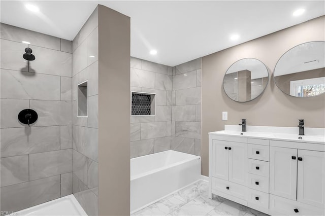 full bathroom with marble finish floor, a sink, a tile shower, recessed lighting, and double vanity