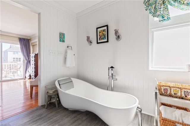 full bathroom featuring a freestanding bath, wood finished floors, and ornamental molding