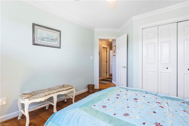 bedroom with a closet, baseboards, wood finished floors, and ornamental molding