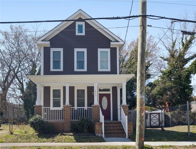 american foursquare style home with a porch and fence