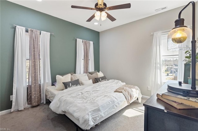 carpeted bedroom with visible vents, baseboards, and ceiling fan