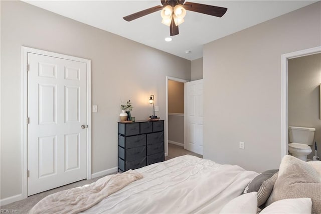 bedroom featuring ensuite bath, carpet, baseboards, and ceiling fan