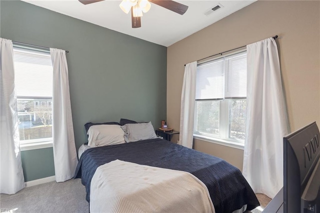 bedroom featuring multiple windows, baseboards, visible vents, and light carpet