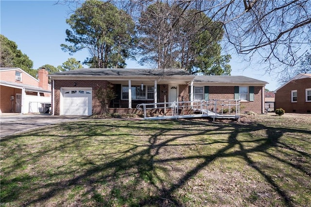 ranch-style home with brick siding, covered porch, a front yard, and a garage