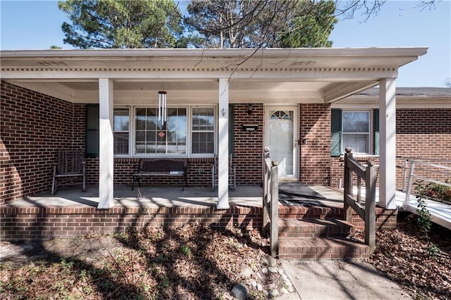 entrance to property with brick siding and covered porch