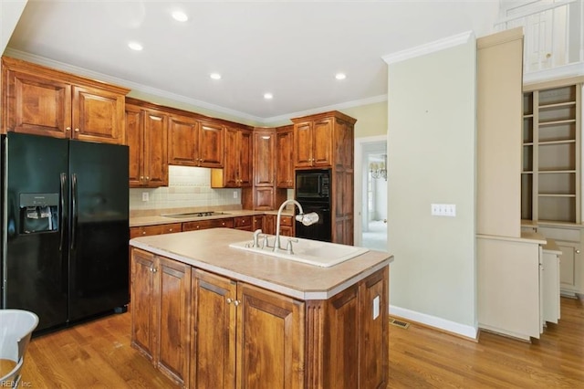 kitchen with black appliances, ornamental molding, a sink, backsplash, and light wood finished floors