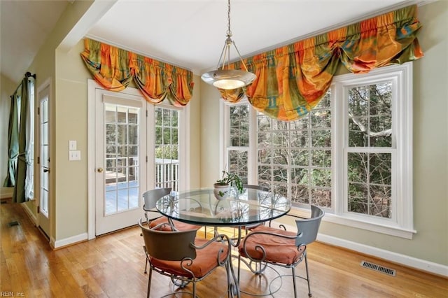 dining room with a wealth of natural light, visible vents, and wood finished floors