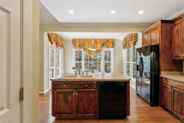 kitchen featuring baseboards, light countertops, wood finished floors, black appliances, and a sink