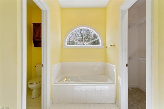 full bath featuring a garden tub, a spacious closet, and toilet