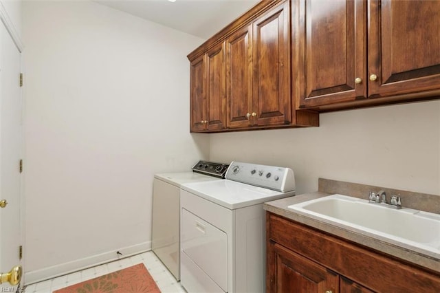 laundry room featuring washer and dryer, baseboards, cabinet space, and a sink