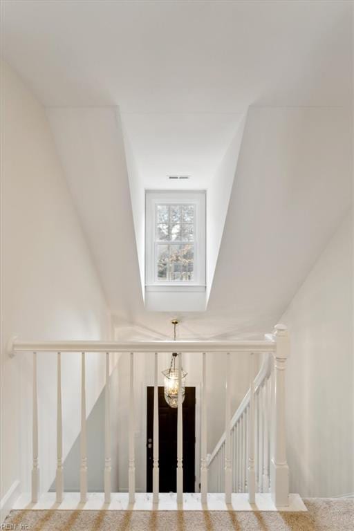 stairs featuring an inviting chandelier