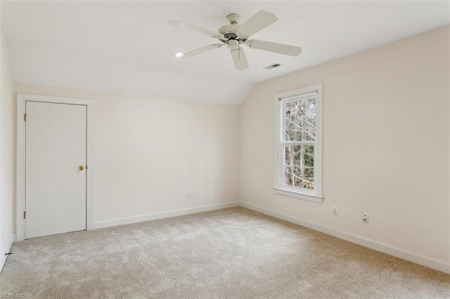 unfurnished room featuring visible vents, carpet flooring, baseboards, ceiling fan, and vaulted ceiling