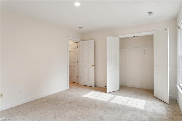 unfurnished bedroom featuring baseboards, a closet, carpet floors, and visible vents