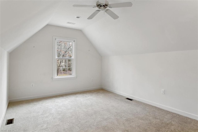 additional living space with vaulted ceiling, carpet flooring, baseboards, and visible vents