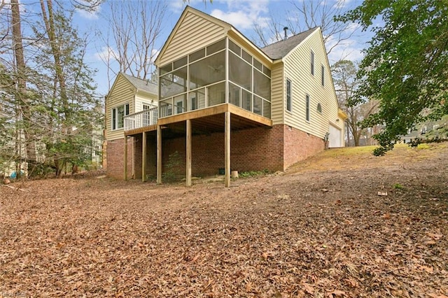 rear view of house with a garage and a sunroom