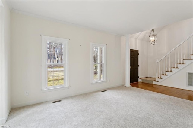 unfurnished living room with visible vents, carpet, stairs, and a notable chandelier