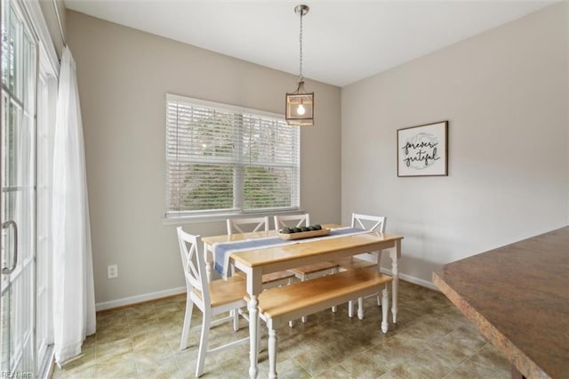 dining room with light tile patterned flooring and baseboards