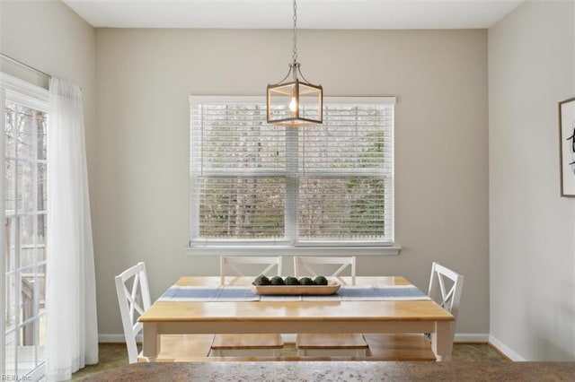 carpeted dining space featuring baseboards