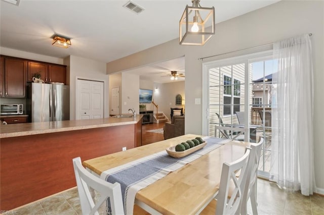 dining space with visible vents, ceiling fan, a toaster, stairway, and light tile patterned floors