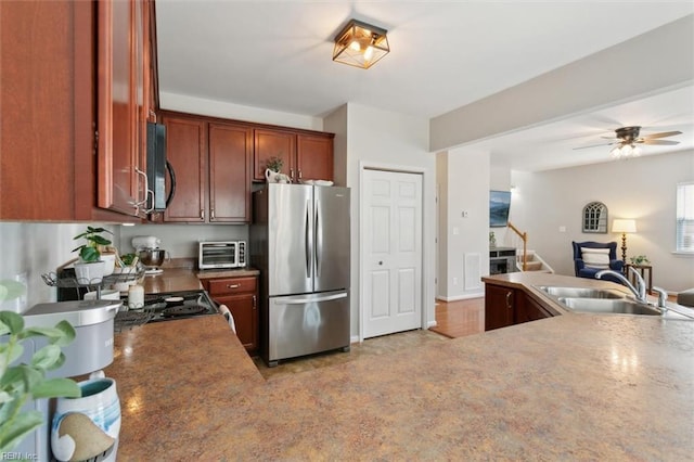 kitchen featuring a ceiling fan, a toaster, freestanding refrigerator, a sink, and black microwave