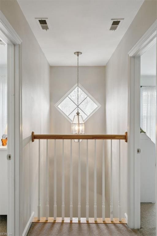 room details featuring visible vents and a notable chandelier