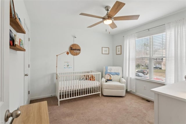 bedroom featuring visible vents, light carpet, a nursery area, and baseboards