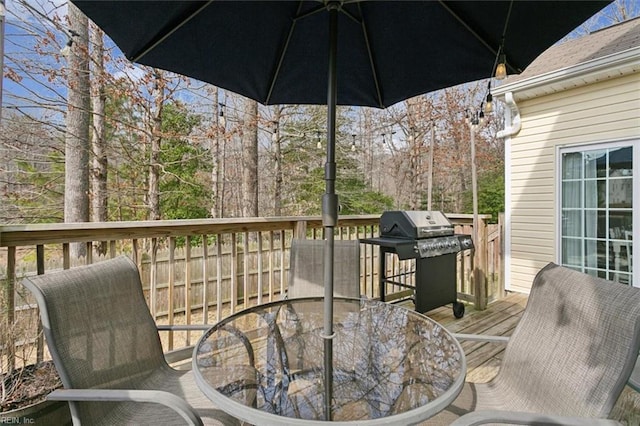 wooden deck featuring a grill and outdoor dining area