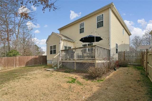 back of house featuring a yard, a wooden deck, and a fenced backyard