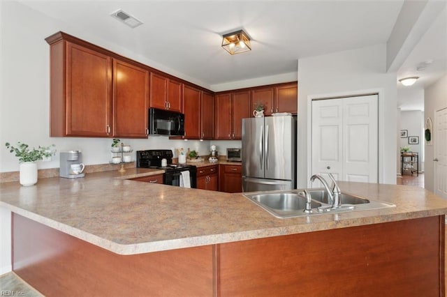 kitchen featuring visible vents, a peninsula, a sink, black appliances, and light countertops