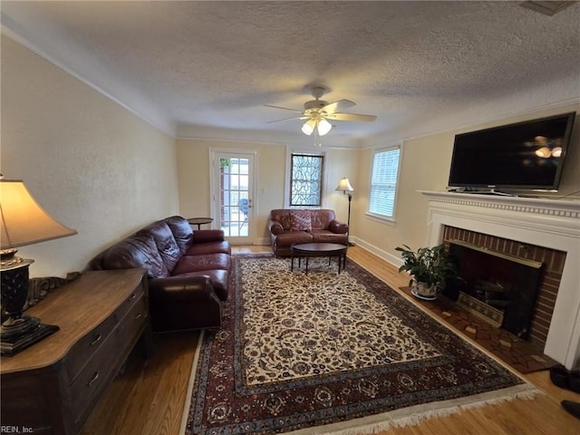 living area featuring a fireplace, wood finished floors, and a textured ceiling