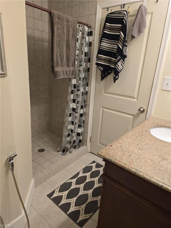 full bath with a stall shower, vanity, and tile patterned flooring