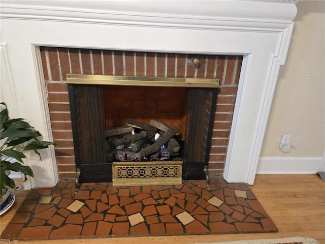 room details featuring wood finished floors, a fireplace, and baseboards