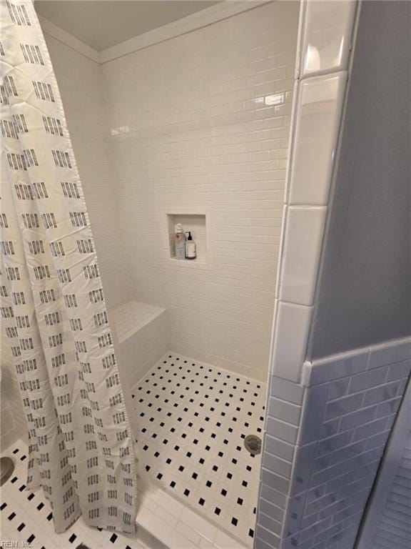 full bathroom with a shower stall and crown molding